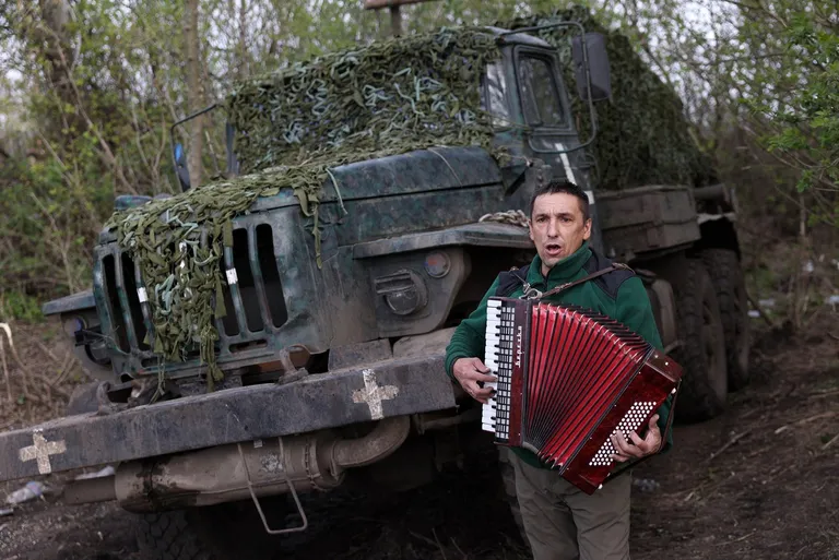 (Фото) Украински војник им свиреше на хармоника на колегите за да им го разубави денот