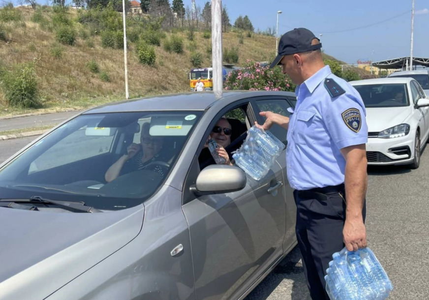 (Фото) Полицајци им даваа вода на туристи кои со часови беа заглавени на граница